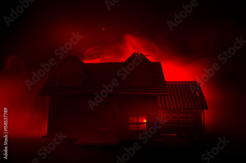 Old house with a Ghost in the moonlit night or Abandoned Haunted Horror House in fog. Old mystic villa with surreal big full moon. Horror concept. photo