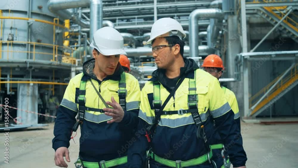 Team of workers walking on industrial factory