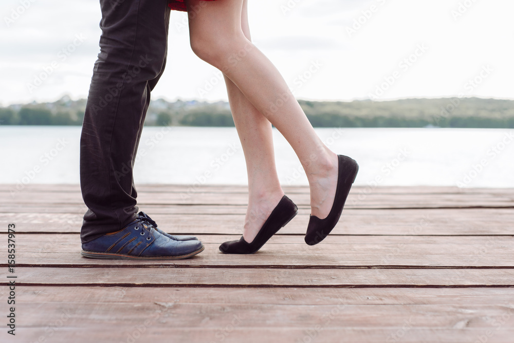 Couple kissing outdoors - Lovers on a romantic date at sunset,girls stands  on tiptoe to kiss her man - Close up on shoes Photos | Adobe Stock