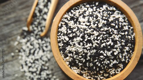 Black and white sesame seed in bamboo basket on a wooden table photo