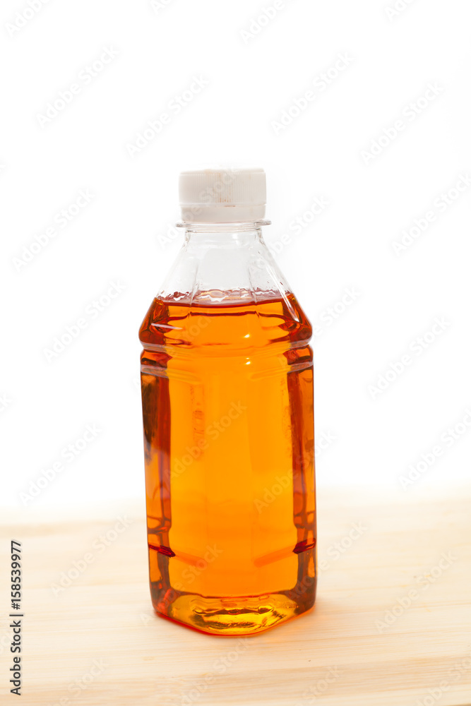 A bottle of maple syrup on a white background. A bottle of maple syrup on a white background.