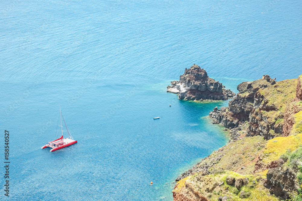 View of the sea and a catamaran from steep coast