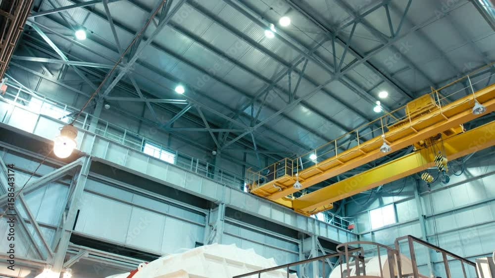 Overhead crane moves in large workshop