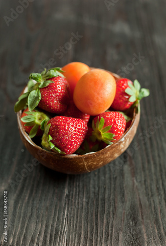 apricots and strawberry on a wooden table