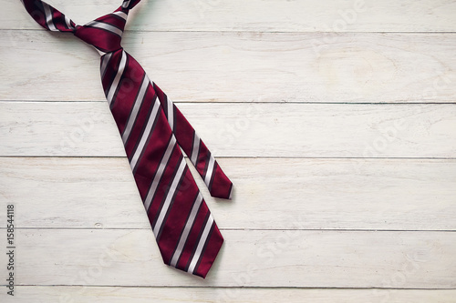 Happy Father's Day inscription with colorful tie and watch on wooden background floor background.