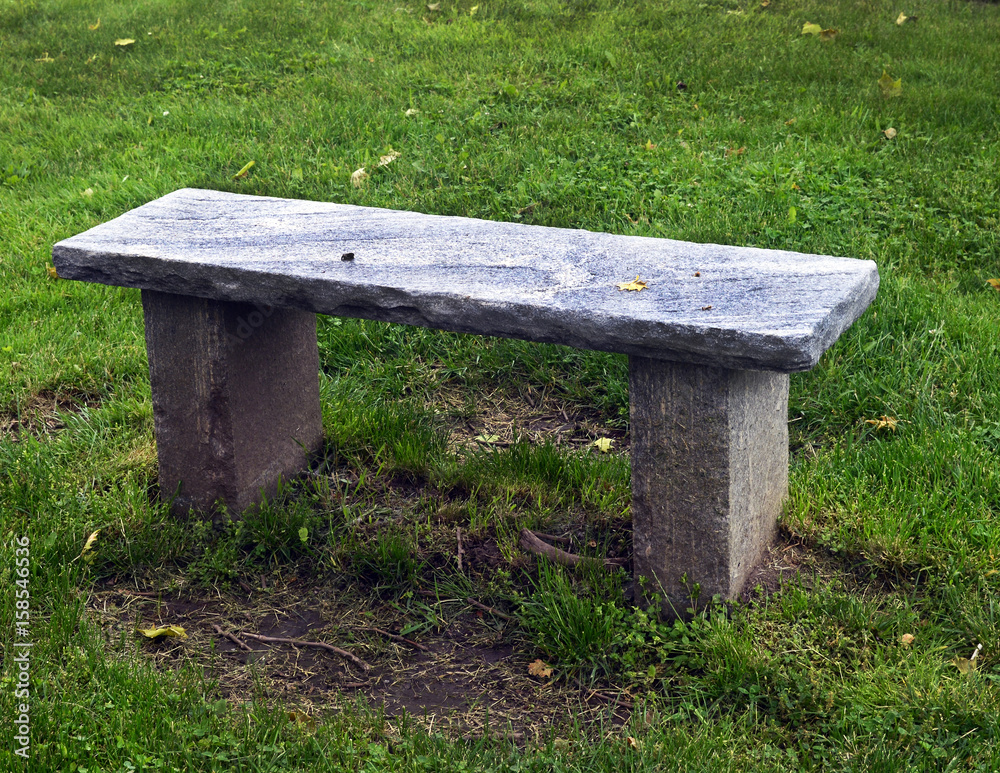Stone bench in grassy area at cemetery Stone bench in grassy area at cemetery