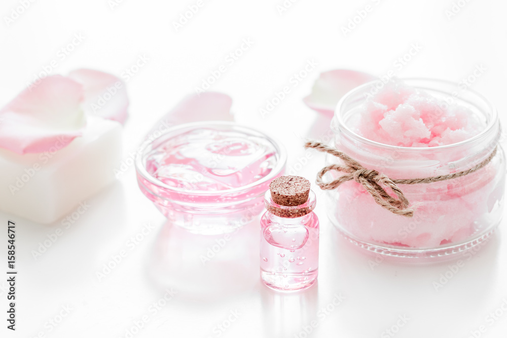 spa set with rose flowers extract and cosmetic for body on white desk background spa set with rose flowers extract and cosmetic for body on white desk background