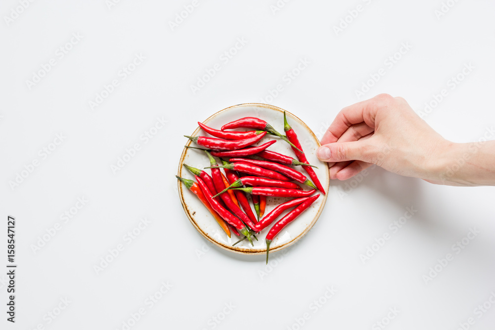 red hot chili pepper design on white table background top view