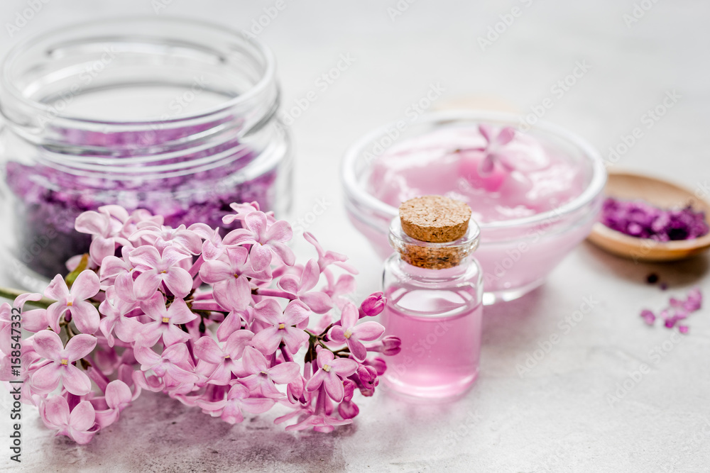 lilac cosmetics with flowers and spa set on stone table background lilac cosmetics with flowers and spa set on stone table background