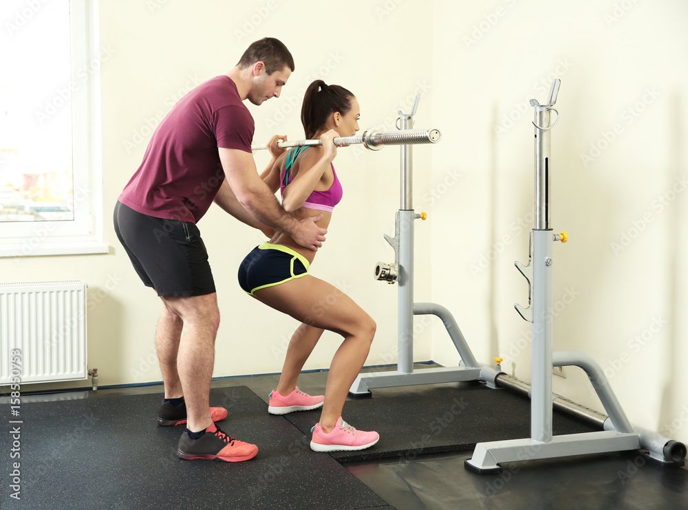 Fototapeta premium Beautiful sportive woman training with her trainer in gym