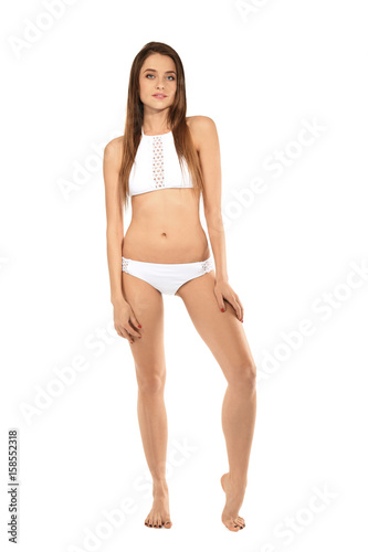 Beautiful young woman in swimsuit on white background