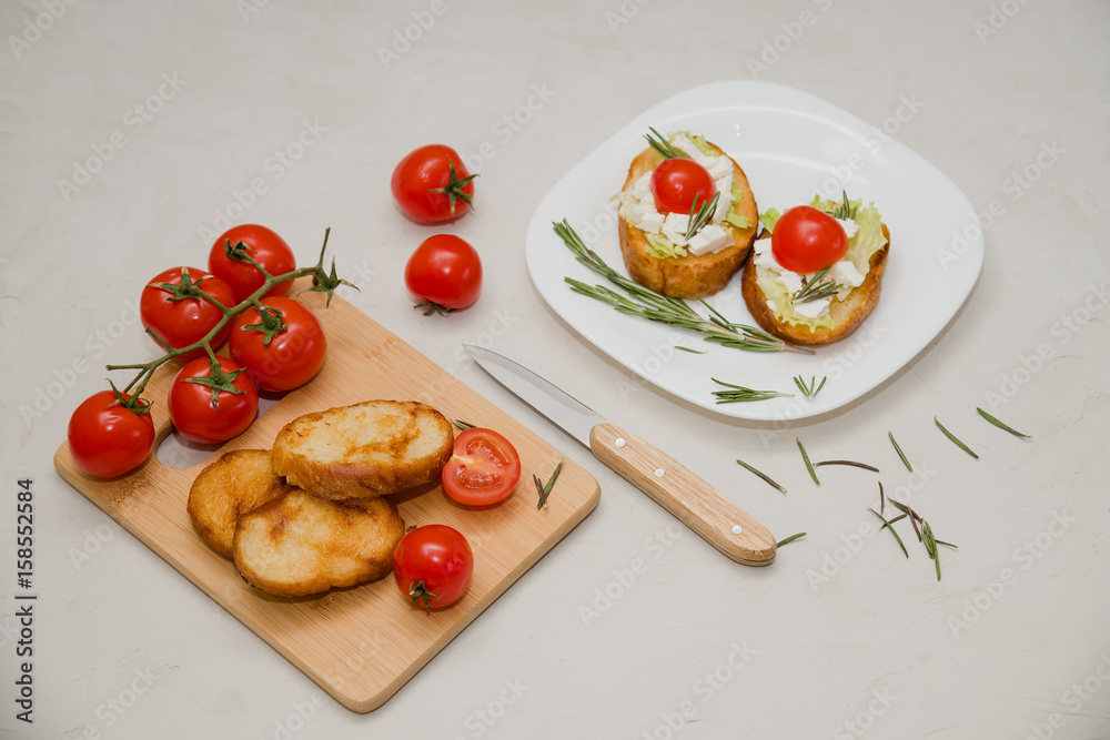 Italian bruschetta with soft cheese, tomatoes, rosemary and fresh salad on the plate. Space for text Italian bruschetta with soft cheese, tomatoes, rosemary and fresh salad on the plate. Space for text