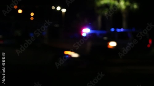 Police lights flashing at night downtown at crime scene, close up.