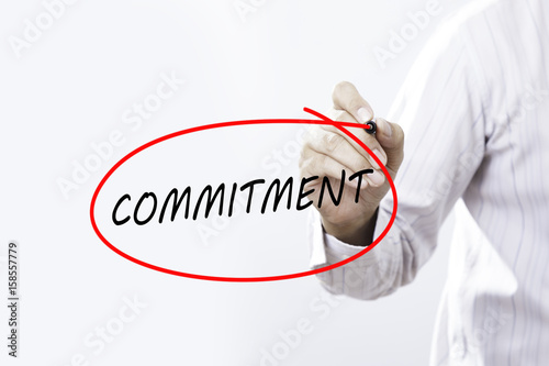 Businessman Hand Writing commitment with a marker over transparent board, Business concept. photo
