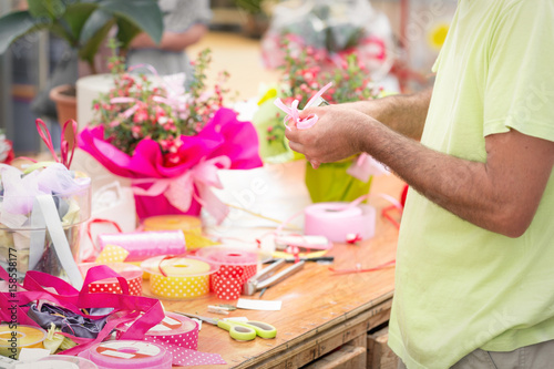 closeup florist making a ribbon bow. Shallow depth of field, focus on hand