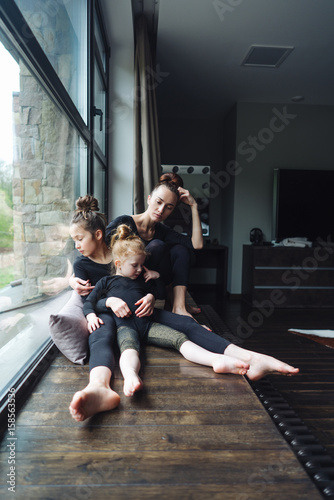 Mom and two daughters together at the window