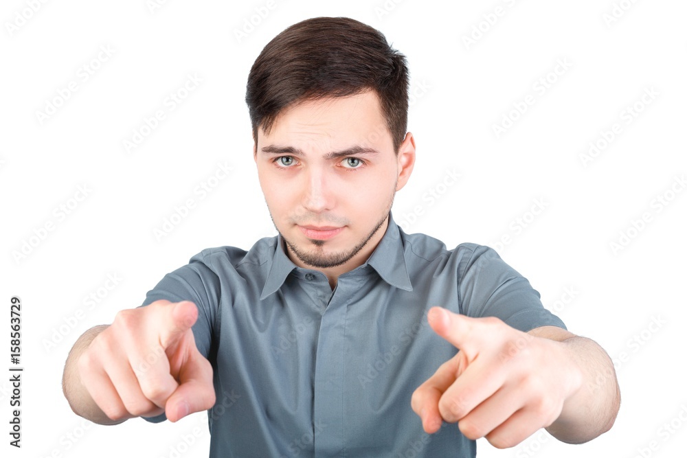 Portrait of a handsome young man pointing finger at you against white background. angry attractive young man pointing a finger towards you Portrait of a handsome young man pointing finger at you against white background. angry attractive young man pointing a finger towards you
