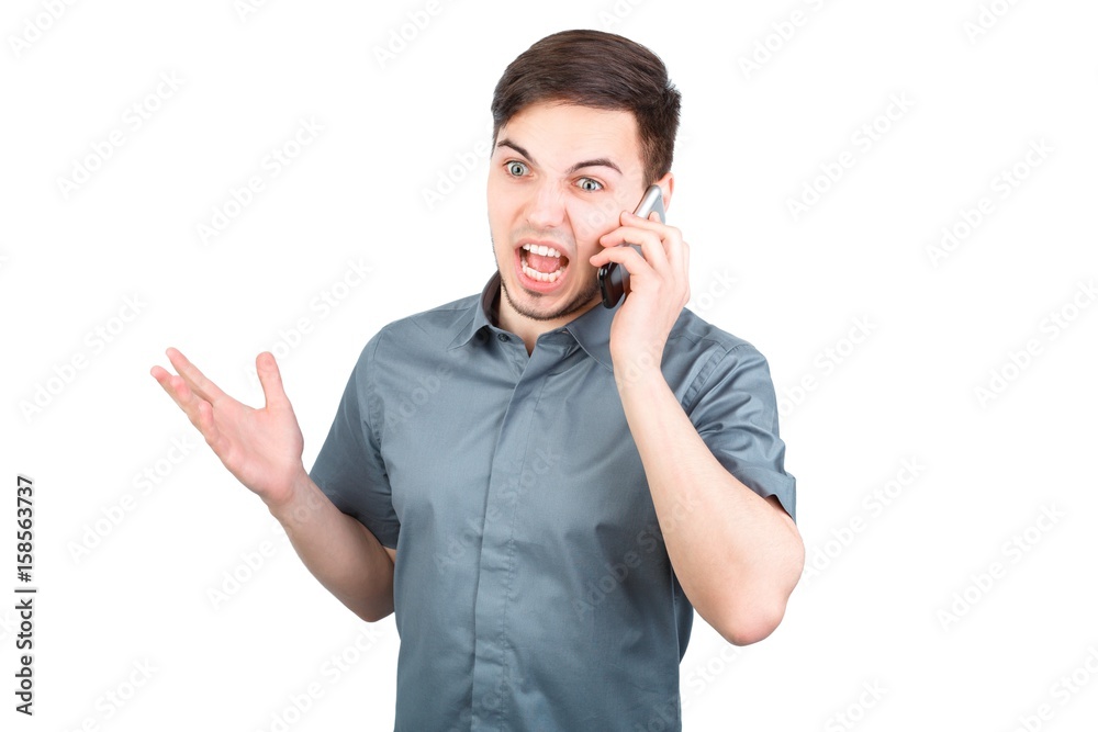 young man answering smartphone over white background. A man is talking on the phone young man answering smartphone over white background. A man is talking on the phone