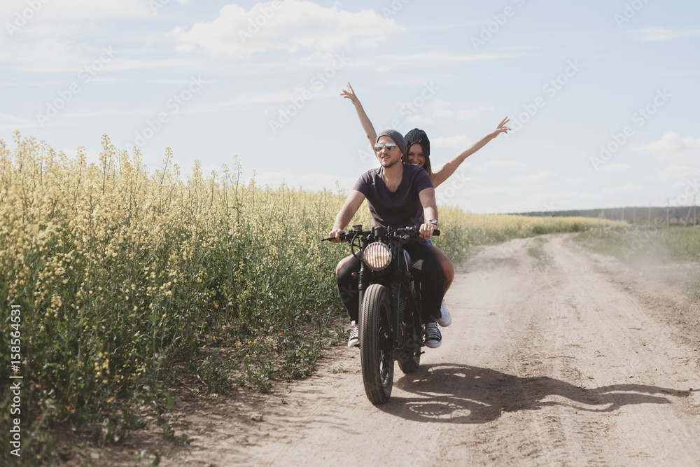Obraz premium couple in field on motorcycle
