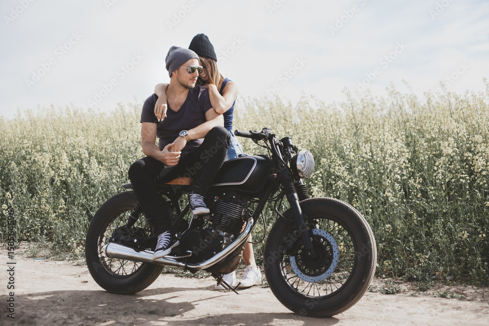Fototapeta couple in field on motorcycle