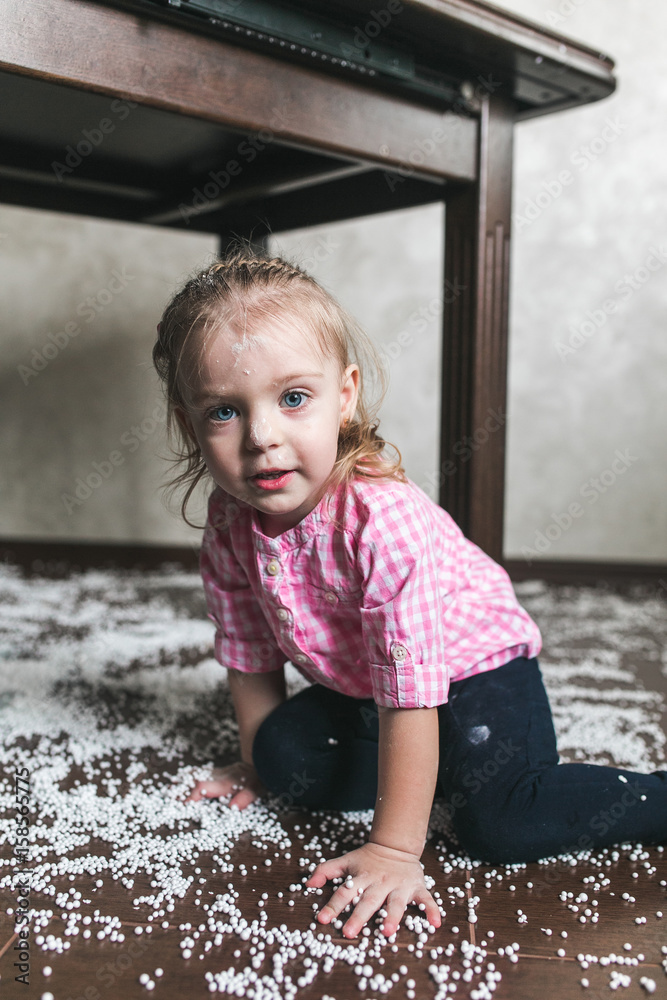 Fototapeta premium Little girl is playing with foam balls