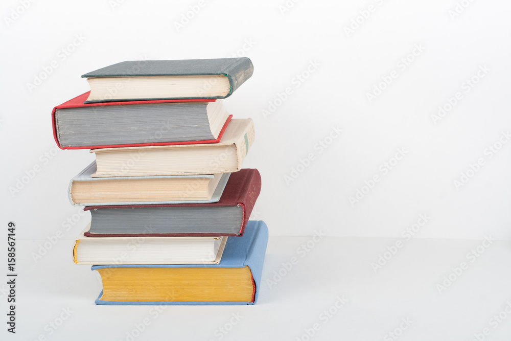 Book stacking. Open book, hardback books on wooden table and white background. Back to school. Copy space for text Book stacking. Open book, hardback books on wooden table and white background. Back to school. Copy space for text