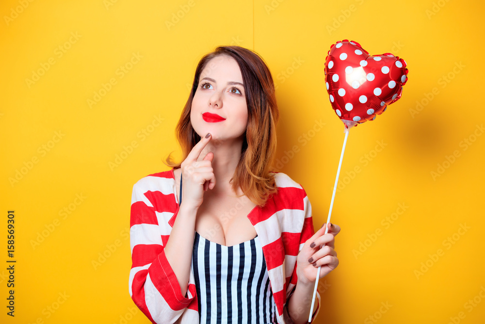 Woman with heart shape toy on yellow background Woman with heart shape toy on yellow background