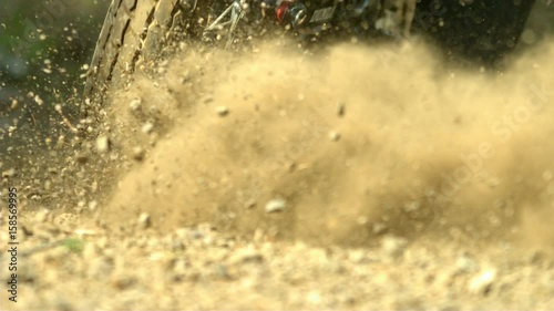 Motorcycle tire spinning in the dirt and rocks in slow motion