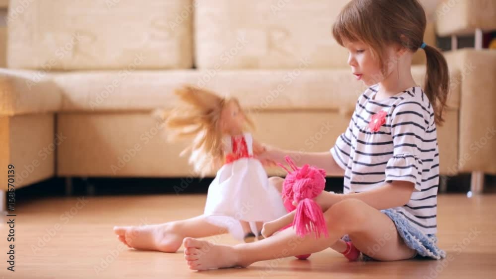 Little girl playing with a dolls
