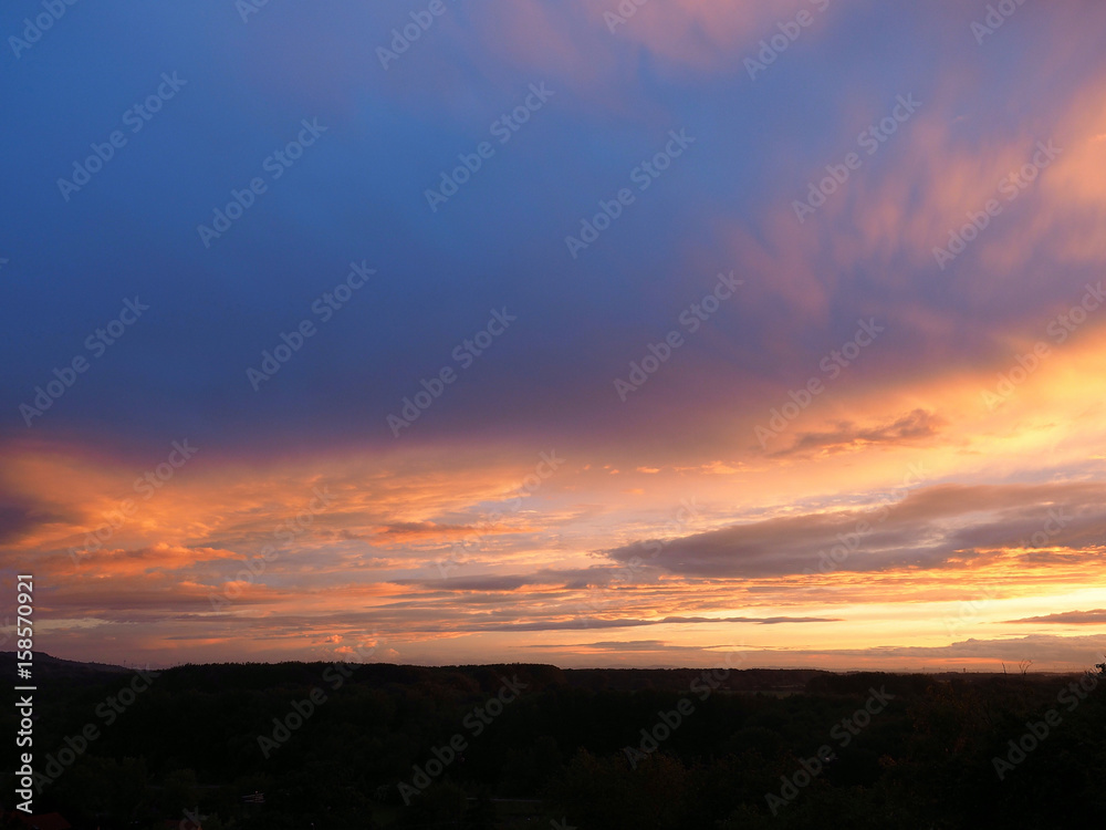 Vibrant orange sunset with clouds.