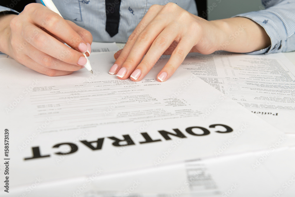 Woman hand signing a contract Woman hand signing a contract