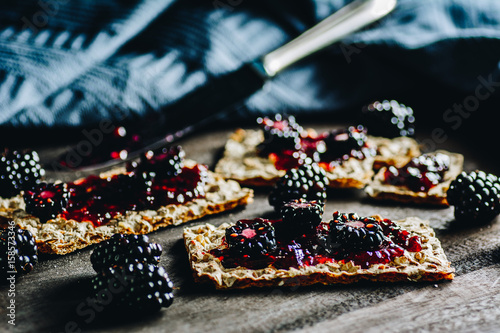 Whole grain bread crackers with jam and blackberries