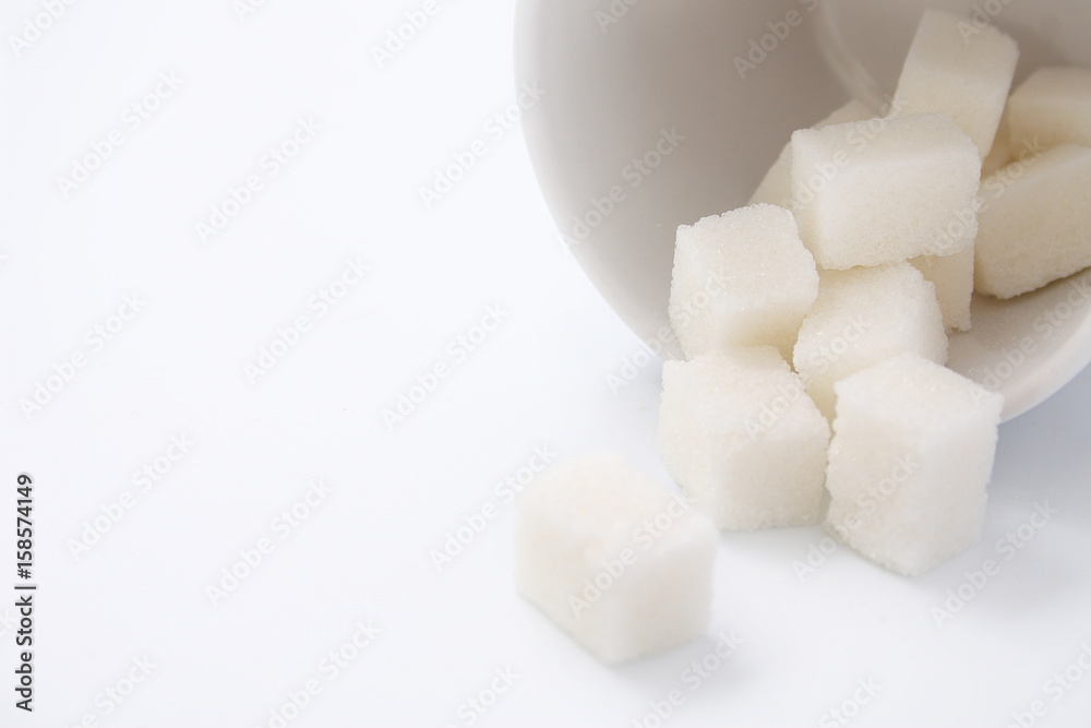 White cup with sugar cubes on white background White cup with sugar cubes on white background