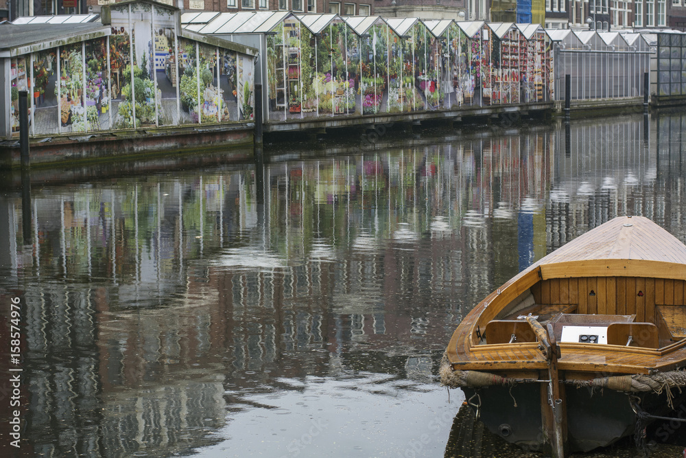 Wooden boat near the flower market in Amsterdam in the Netherlands in the cloudy day Wooden boat near the flower market in Amsterdam in the Netherlands in the cloudy day