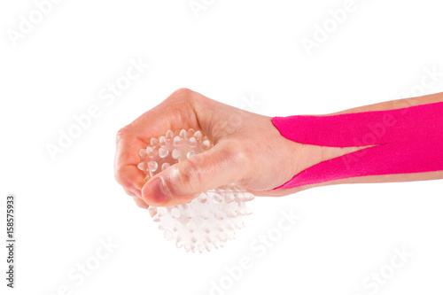 hand with kinesiology tape and stressball.  photo