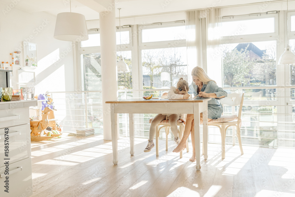 Mature woman and girl at home drawing together Mature woman and girl at home drawing together