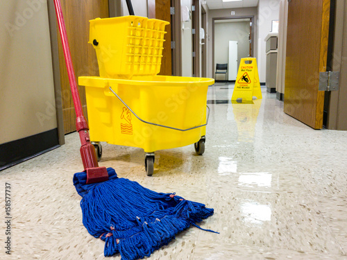 Wet floor with mop bucket and wet floor sign