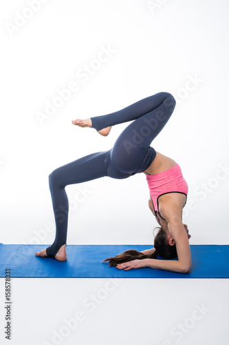 young beautiful woman yoga posing on isolated white studio background