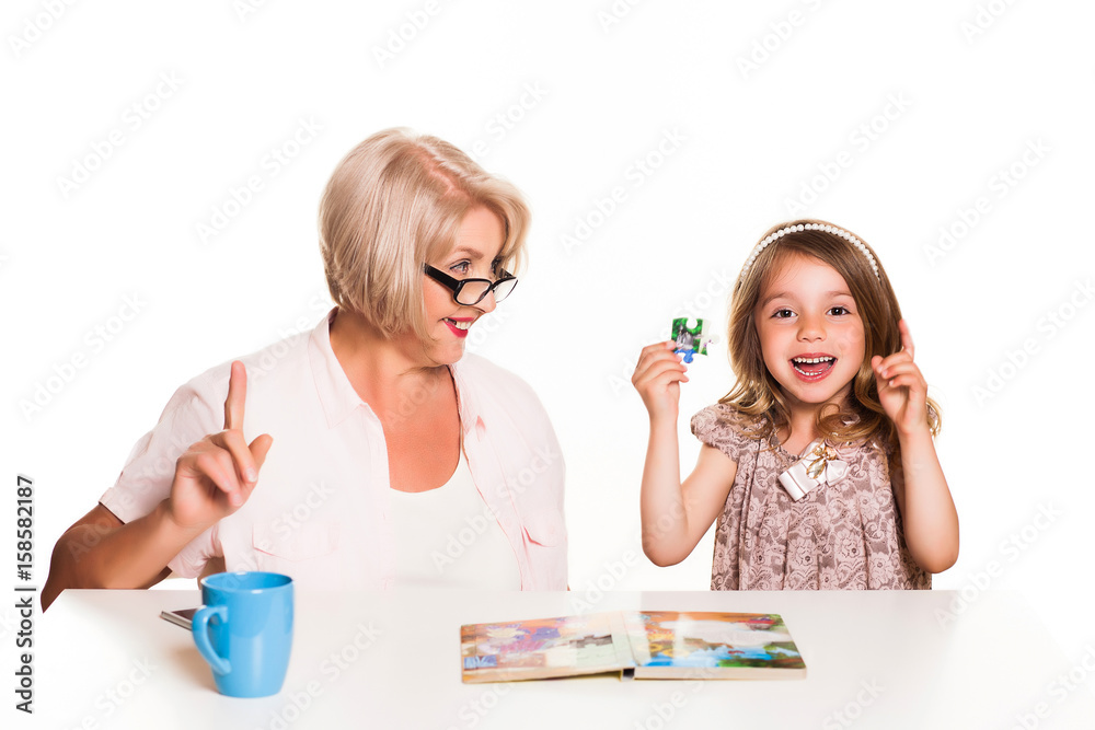 Grandmother and granddaughter read a book and Add the puzzleon white background Grandmother and granddaughter read a book and Add the puzzleon white background