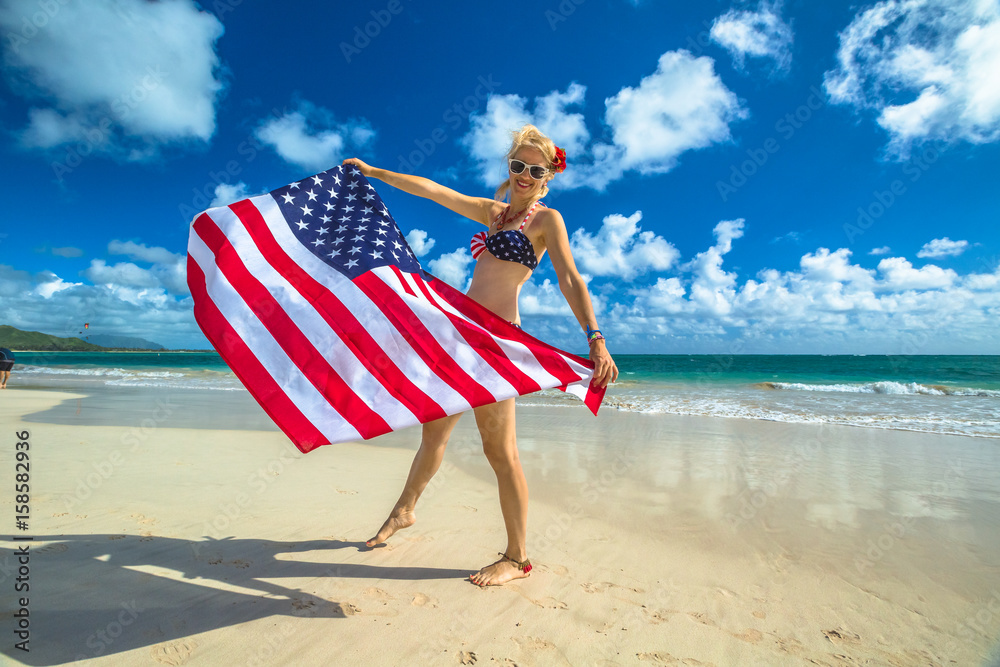Φωτογραφία Smiling woman with american flag bikini waving american flag in spectacular tropical Lanikai Beach, east shore of Oahu in Hawaii, USA