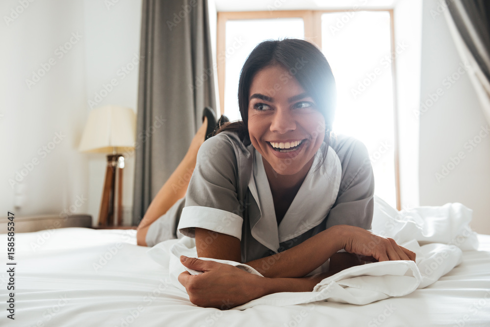 Smiling hotel maid lying on a bed Smiling hotel maid lying on a bed