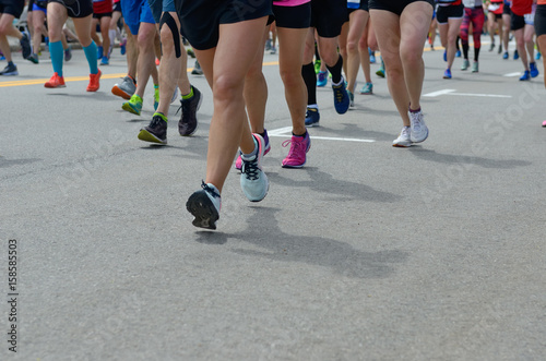 Marathon running race, many runners feet on road, sport, fitness and healthy lifestyle concept 