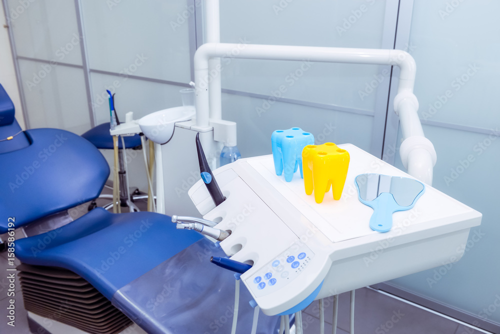 Φωτογραφία Close-up bright toothbrush holders in form of tooth and dental instruments in dentist's office