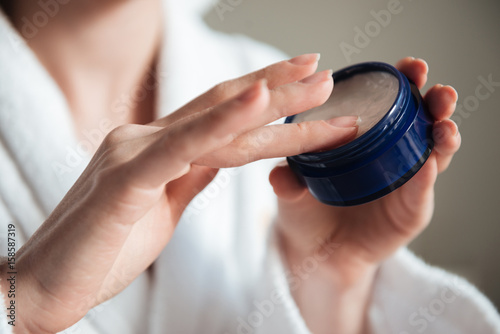 Close up of a young woman hands holding jar of cream