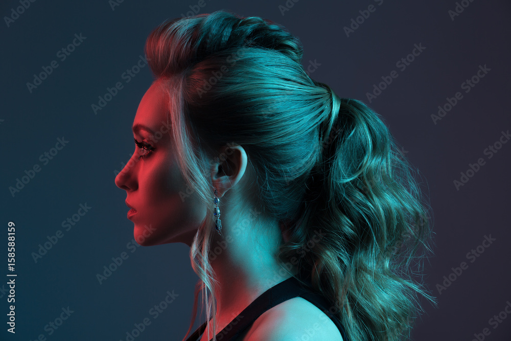Fashion portrait of beautiful  woman. Hairstyle. Blue and red light.