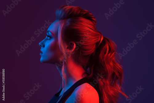 Fashion portrait of beautiful  woman. Hairstyle. Blue and red light.