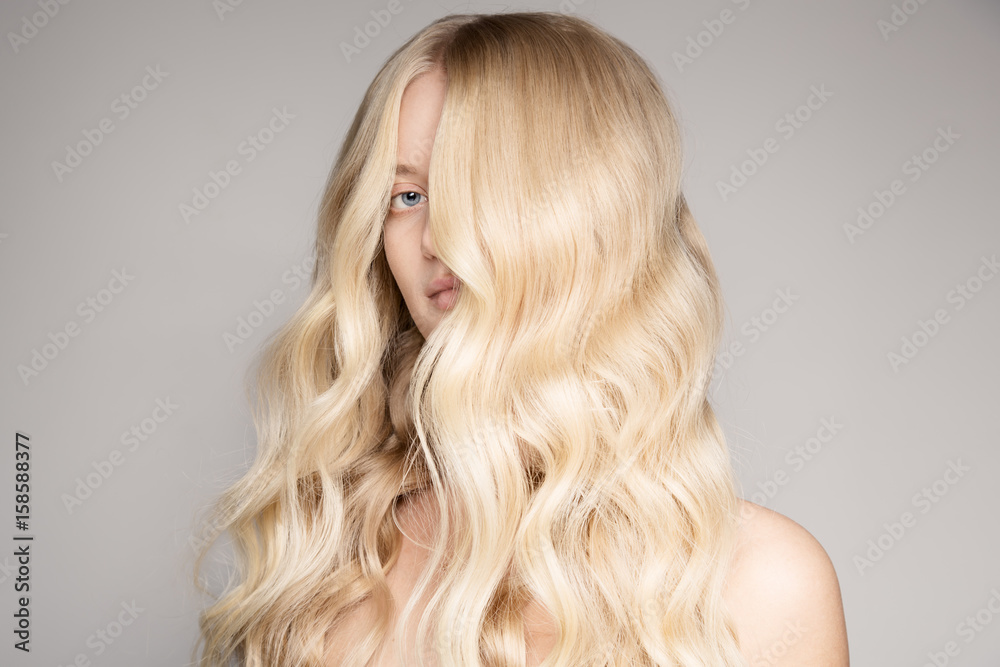 Naklejka premium Portrait Of A Beautiful Young Blond Woman With Long Wavy Hair.