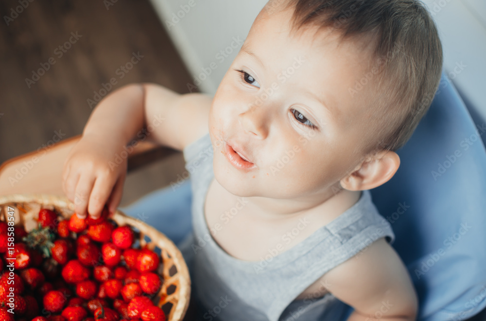 the child in the kitchen eating strawberries the child in the kitchen eating strawberries