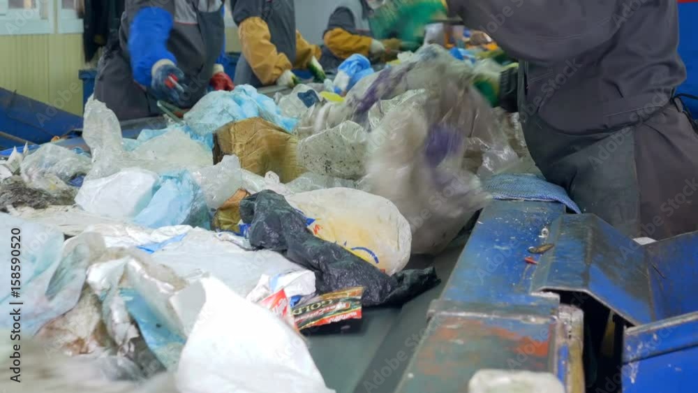 Plant workers sorting waste manually. Plant workers sorting waste manually.