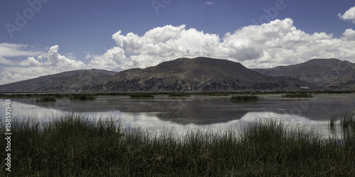 Reed, lake, mountains and clouds with reflection in the lake Titicaca, Peru © Angel